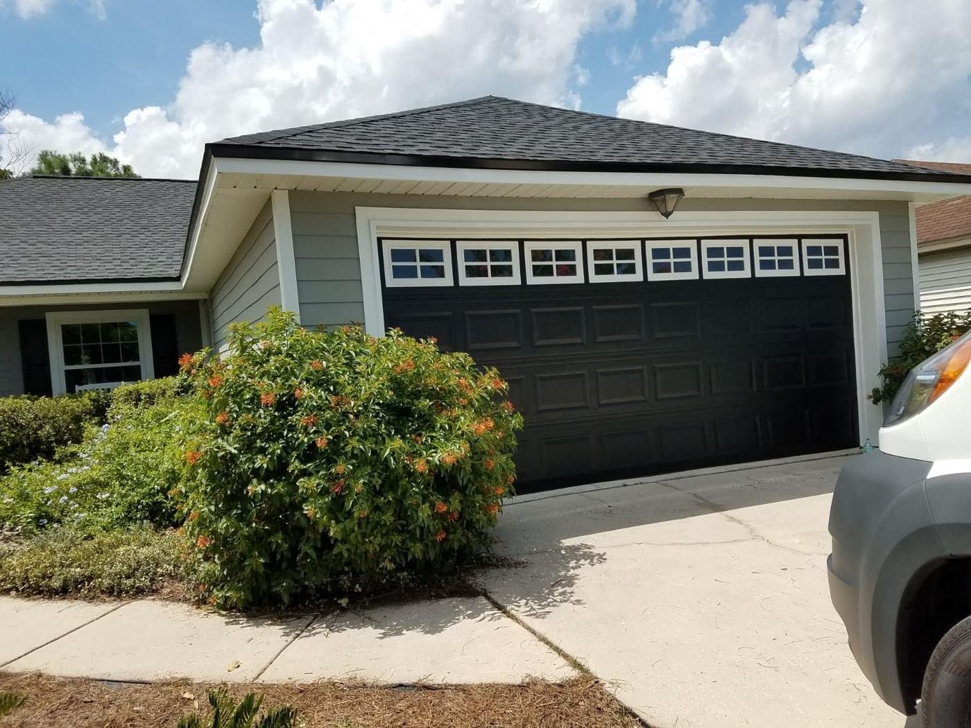 Gray siding with a dark garage door and white trim