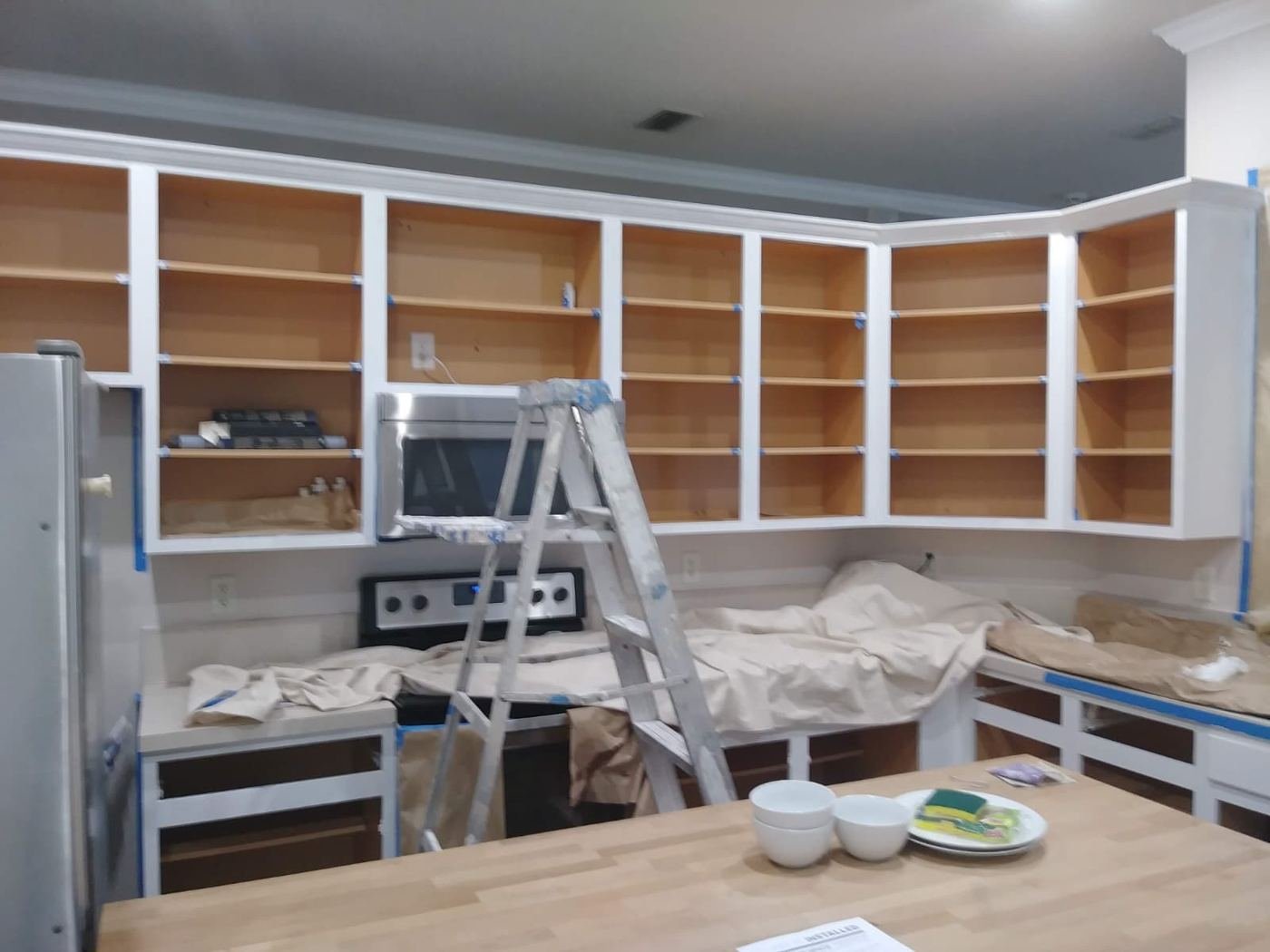 Cabinet boxes prepped for refinishing, doors removed