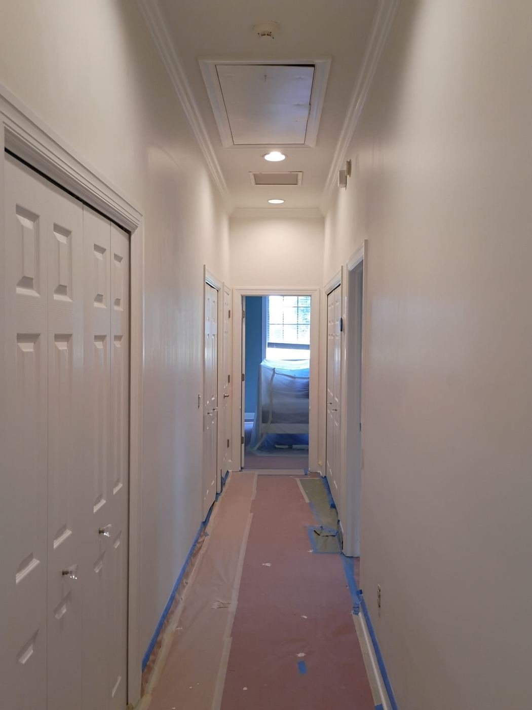 White hallway with floors protected