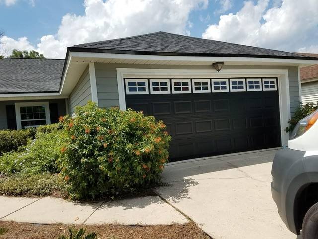 Gray siding with a dark garage door and white trim