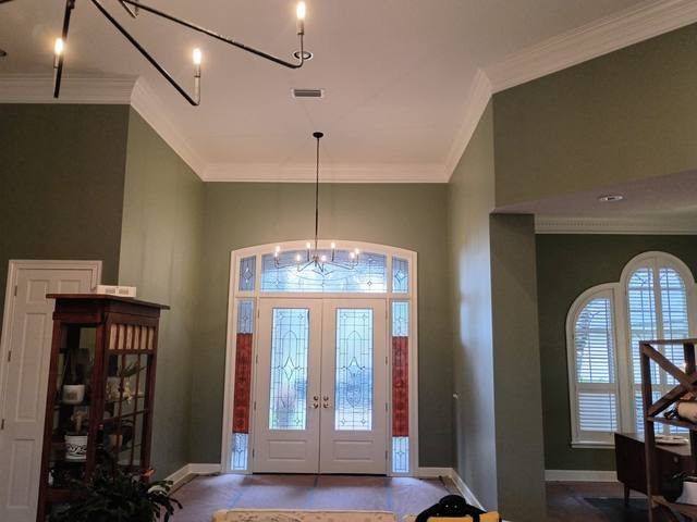Two-story foyer finished in sage green with crisp white trim